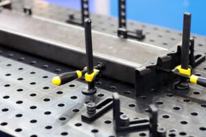 Workpieces on a welding table with clamps and fixtures. Selective focus.