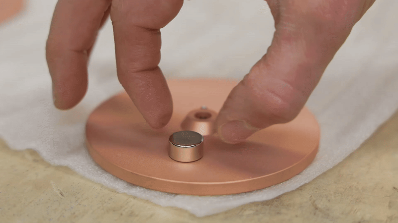 Though copper isn’t magnetic, the falling magnet slows slightly as eddy currents create resistance just before contact.©