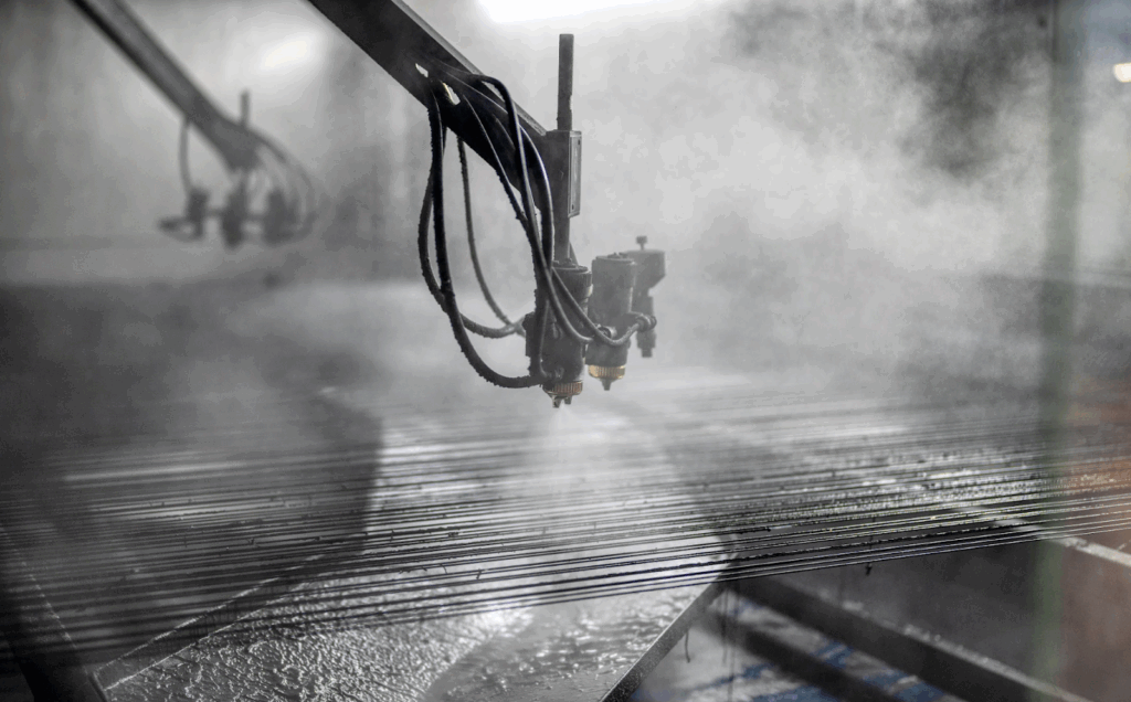 Metal part on a conveyor line being sprayed