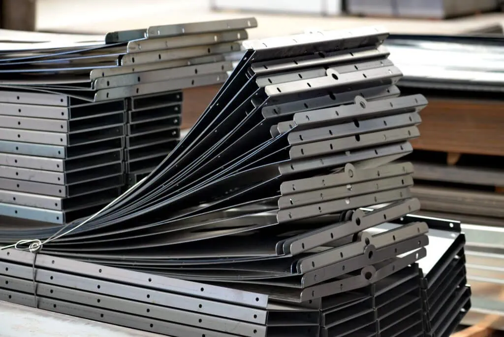 A neat stack of finished sheet metal parts, showing precise holes and bends.