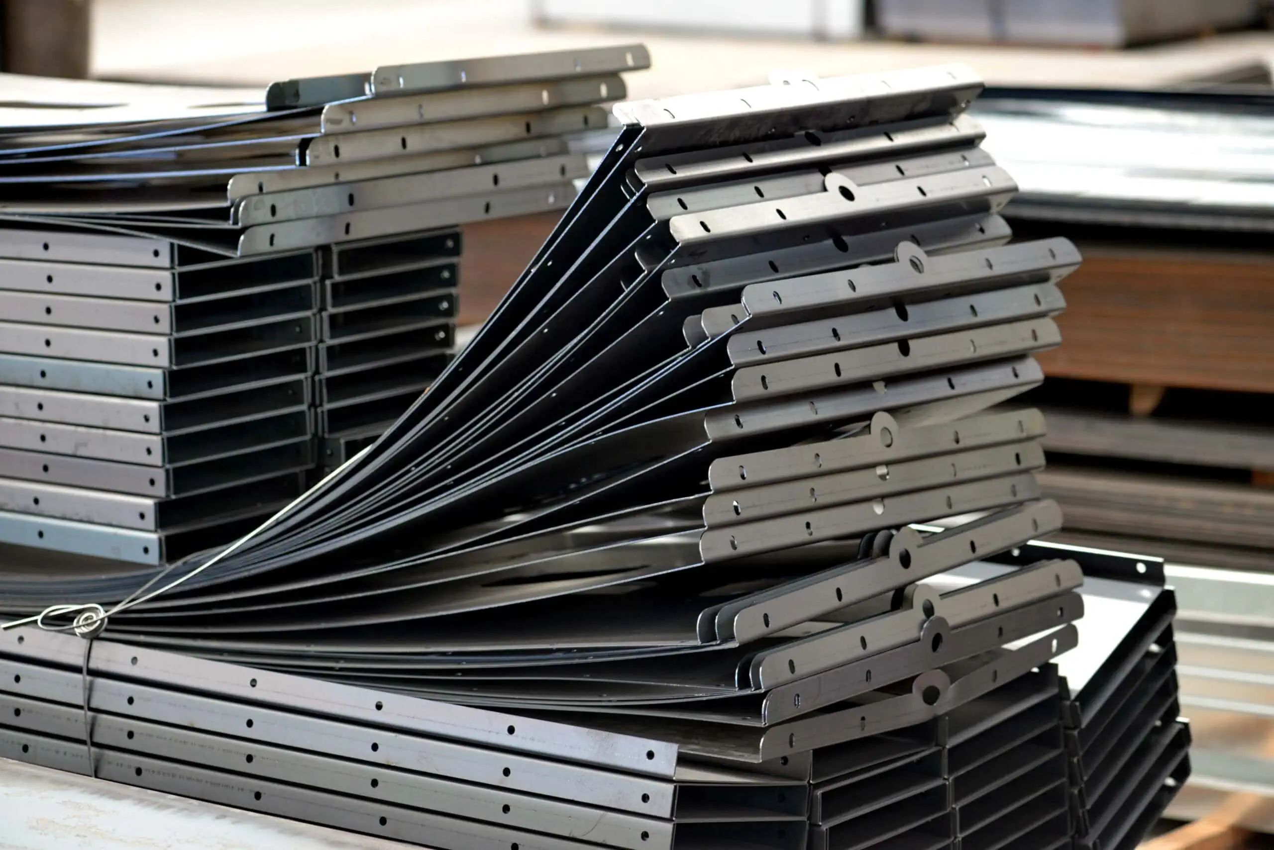 A neat stack of finished sheet metal parts, showing precise holes and bends.